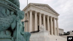 A police officer walks outside the Supreme Court on Capitol Hill in Washington, Monday, July 6, 2020. (AP Photo/Patrick Semansky)