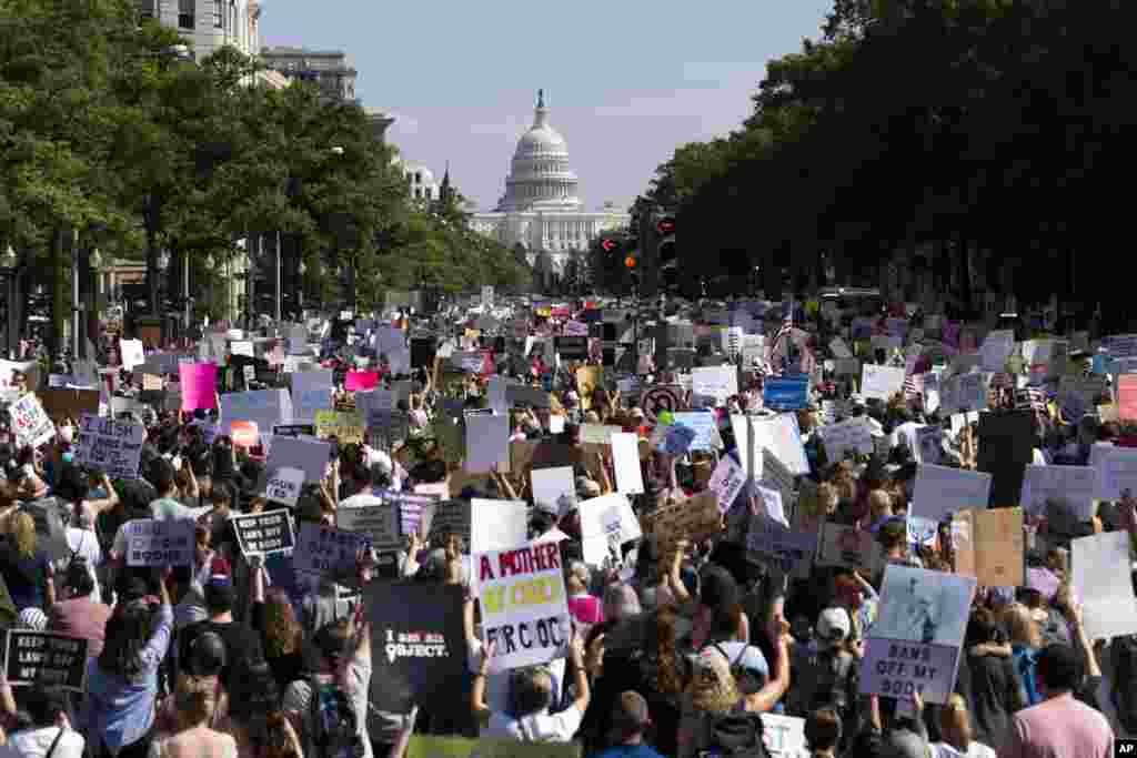 With the U.S Capitol in the background, thousands of demonstrators march on Pennsylvania Avenue during the Women's March in Washington, Oct. 2, 2021.