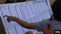 Voters verify their names at a polling station in Ariksat commune of Kandal province, which is the stronghold of the opposition CNRP. (Sun Narin/VOA Khmer)