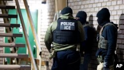 Ajan Imigrasyon ak Ranfosman La Dwann tann pou arete yon moun Lendi 27 Janvye 2025 nan Silver Spring, Maryland. 