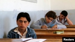 FILE - Students are seen taking exams in Hama, Syria, May 10, 2014. 
