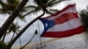A Puerto Rican flag tied to a swing waves in the wind as Tropical Storm Ernesto approaches Loiza, Puerto Rico, on Aug. 13, 2024.