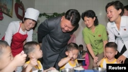 មេដឹកនាំ​កូរ៉េ​ខាង​ជើង​ Kim Jong Un ញញឹម​ខណៈ​ពេល​ដែល​ក្មេងៗ​ញ៉ាំ​អាហារ​កំឡុង​ទស្សនៈកិច្ច​នៅ​មណ្ឌល​កុមារ​កំព្រា​ព្យុងយ៉ាង​នៅ​ទិវា​កុមារ​អន្តរជាតិ​កាលពី​ថ្ងៃទី២ ខែមិថុនា ឆ្នាំ២០១៤។