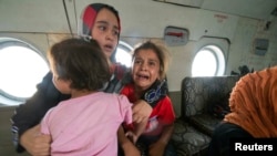 Seorang perempuan dan anak-anak di helikopter militer setelah dievakuasi oleh pasukan Irak dari Amerli, Baghdad utara, 29 Agustus 2014.