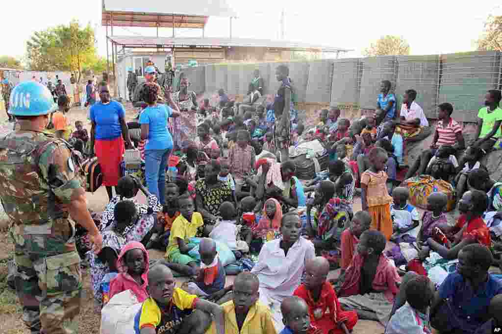A United Nation soldier stands guard as civilians arrive at the UNMISS compound adjacent to Juba International Airport to take refuge.
